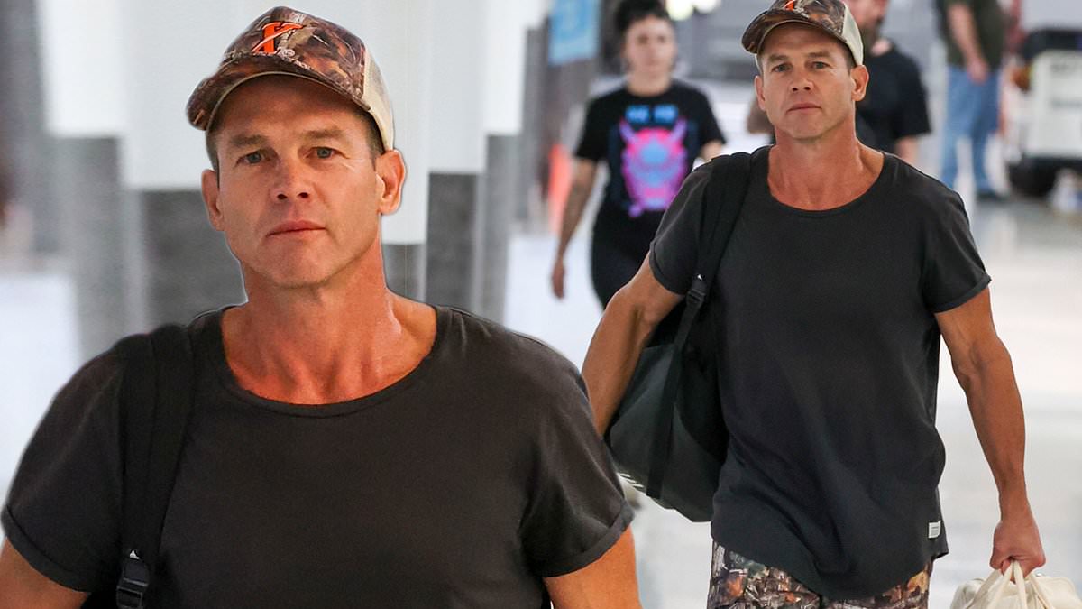 alert-–-afl-legend-ben-cousins-looks-happy-and-healthy-as-he-poses-for-photos-with-fans-after-arriving-at-sydney-airport