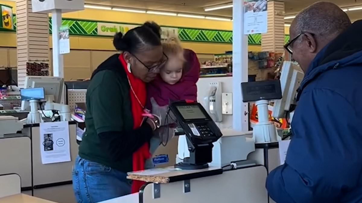 alert-–-heartwarming-moment-dollar-tree-cashier-helps-mom-at-checkout-deal-with-her-crying-toddler,-2,-on-the-brink-of-a-meltdown-by-picking-her-up-to-scan-items-with-her