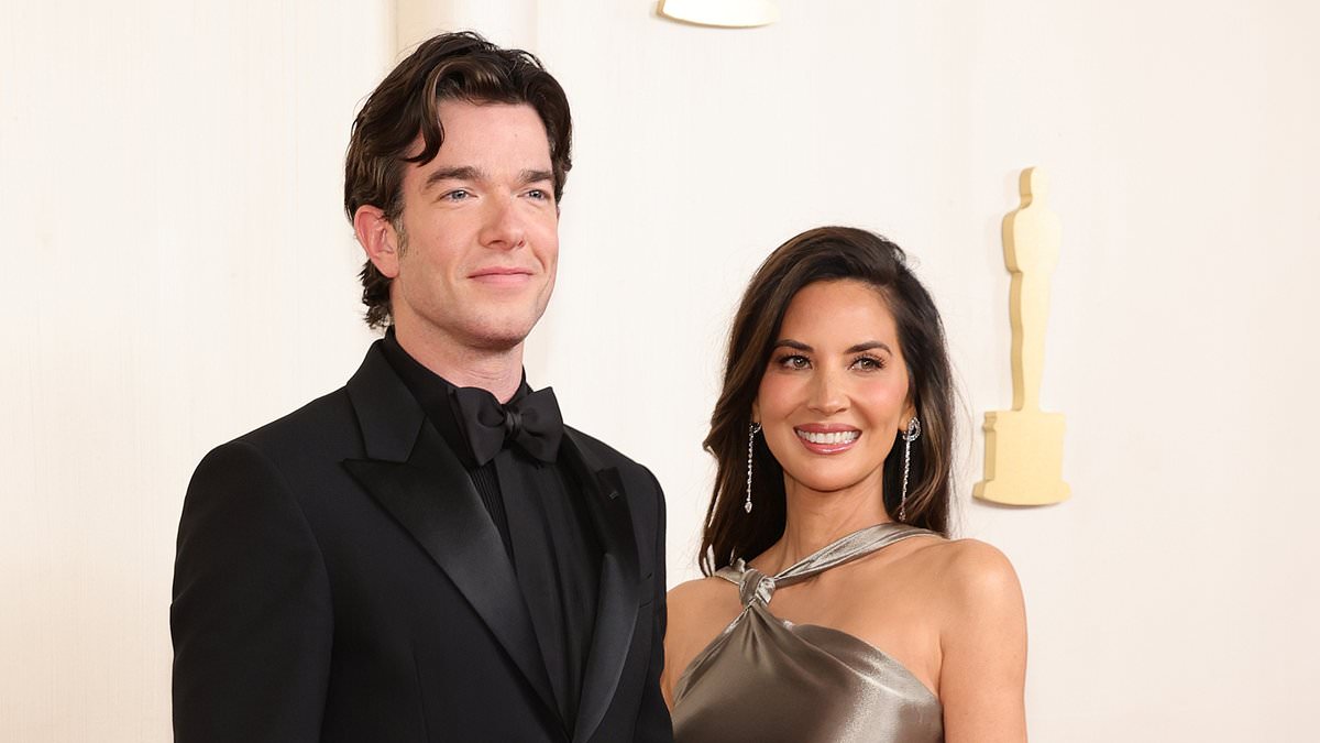 alert-–-oscars-2024:-john-mulaney-sweetly-fixes-olivia-munn-long-train-as-they-pose-together-on-red-carpet