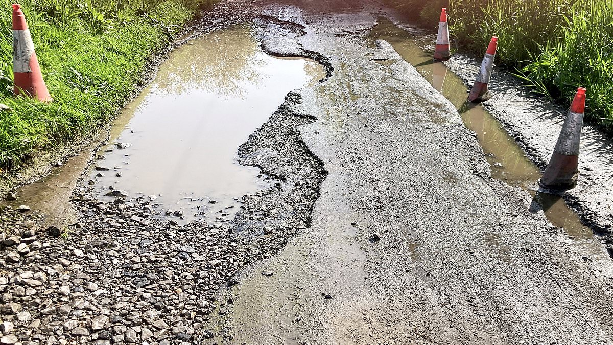 alert-–-is-this-britain’s-biggest-pothole?-eight-inch-deep-crater-the-length-of-a-double-decker-bus-is-blamed-for-damaging-cars-and-leaving-chocolate-box-village-isolated