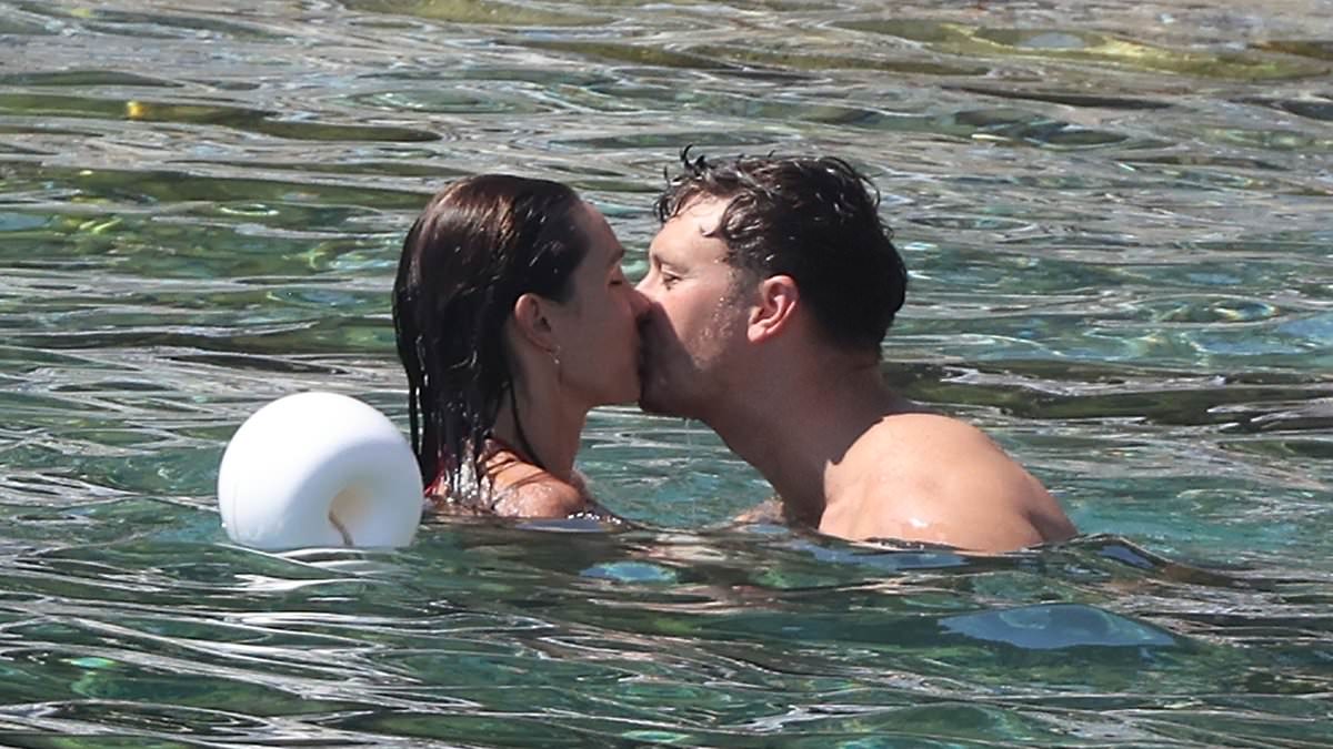 alert-–-fitness-guru-kayla-itsines-shows-off-her-figure-in-a-black-bikini-and-packs-on-the-pda-with-her-husband-jae-woodroffe-during-cosy-swim-in-sicily