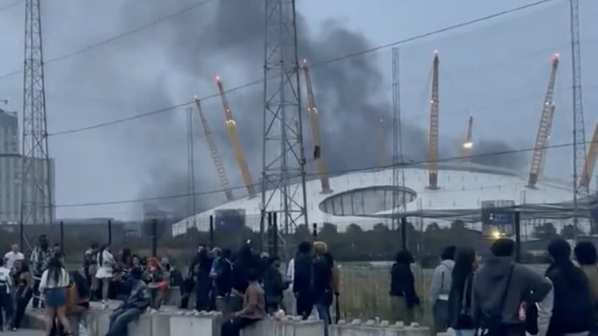 alert-–-panic-as-film-set-inferno-rages-out-of-control-yards-from-london’s-o2-arena-with-explosions-and-thick-smoke-leaving-locals-fearing-a-bomb-had-gone-off:-fire-brigade-battle-to-bring-blaze-under-control-after-‘pre-planned’-stunt-goes-wrong