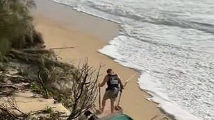 alert-–-watch-the-moment-‘idiot’-aussie-using-a-metal-detector-is-almost-swept-away-by-waves-ahead-of-cyclone-alfred