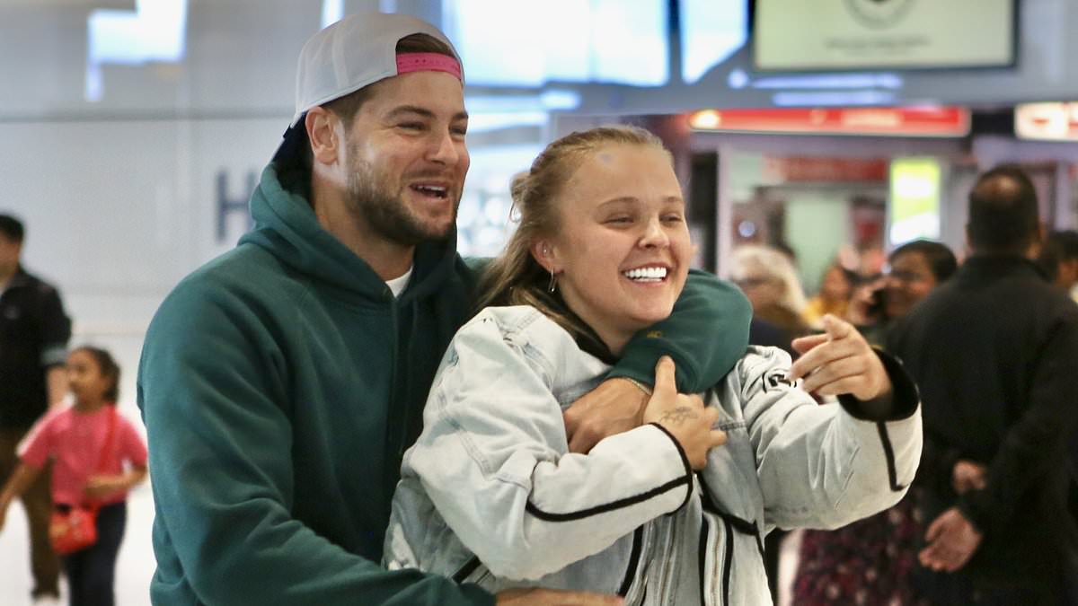 alert-–-chris-hughes-sweetly-welcomes-jojo-siwa-back-to-the-uk-with-a-bunch-of-red-roses-as-the-pair-leave-heathrow-hand-in-hand-after-confirming-romance