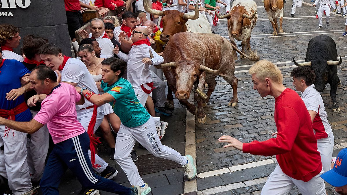 alert-–-pamplona-bull-runners-are-tossed-around-and-trampled-with-at-least-six-injured-under-the-hooves-of-rampaging-animals-as-famous-spanish-festival-gets-underway